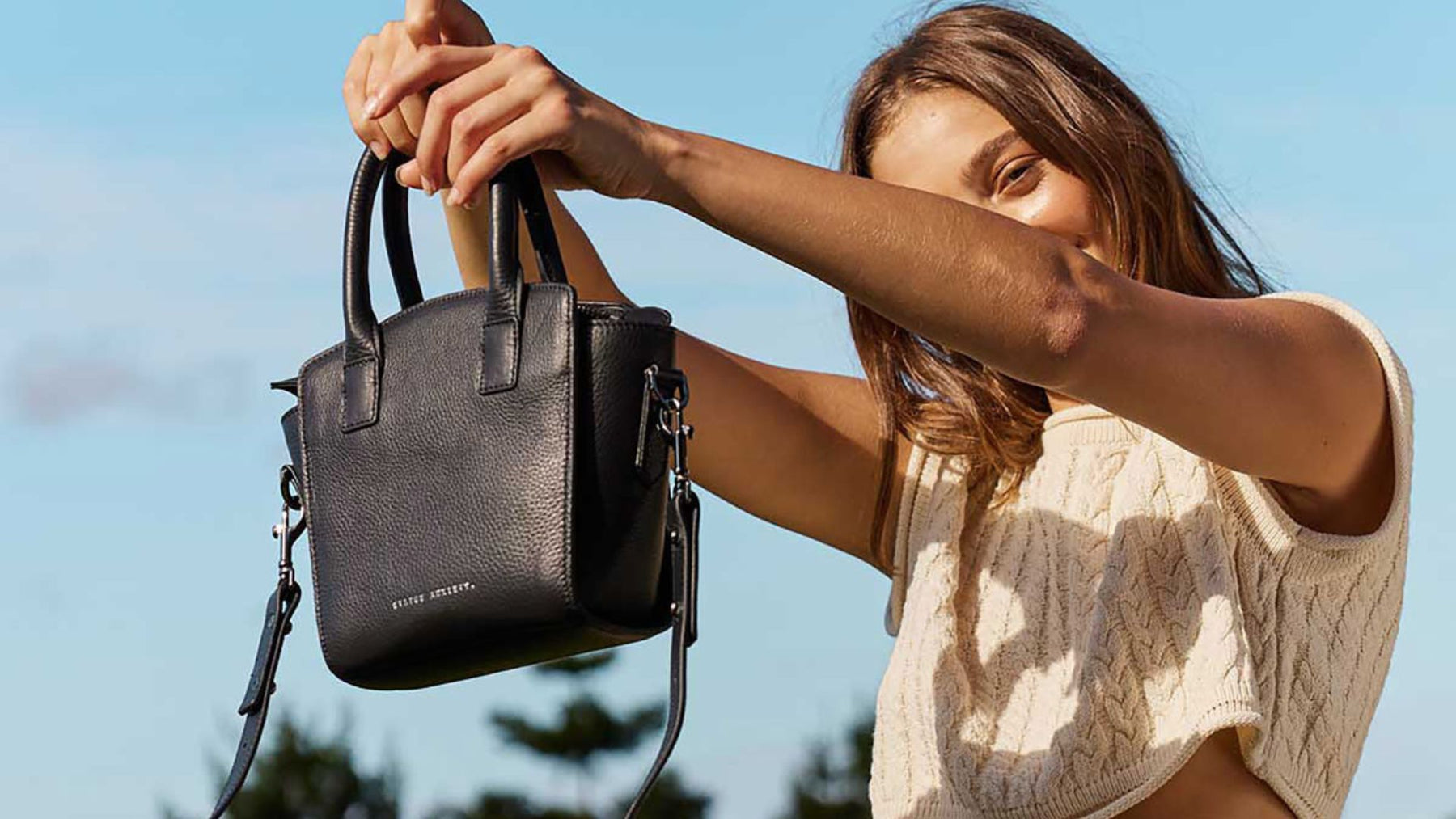 Woman holding up a Status Anxiety bag